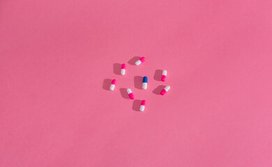 White and blue pill between white and pink pills. Medicine concept.