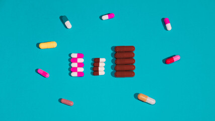 Rows of pills with different pills around on blue background. Medicine concept.