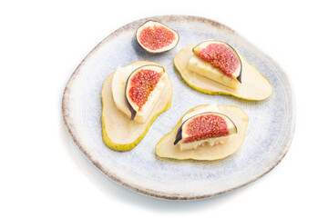 Summer appetizer with pear, cottage cheese, figs and honey on ceramic plate isolated on white background. Side view.