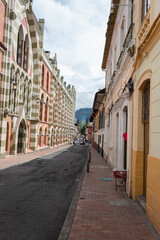 BOGOTA, COLOMBIA  La Candelaria, a famous colonial neighborhood street with colored houses and modern skyscraper at background with cloudy sky