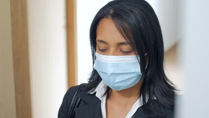 A formally dressed woman is being tested for her body temperature in her forehead - Powered by Adobe