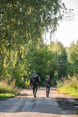 Obraz premium Father's day. Father with gun showing something to son while hunting on a nature. Happy family, Fathers Day and local summer vacation