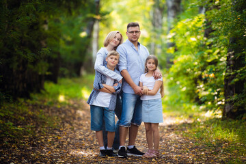 Happy family outdoor portrait in a forest - 386534957