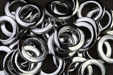 Glossy nickel-plated or chrome-plated Eyelets for attaching curtains in the design workshop. © Iurii Gagarin