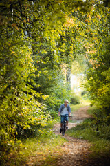 Obraz premium Boy rides the bike in the autumn forest