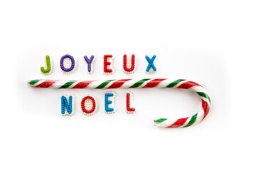 Joyeux Noël in French for Merry Christmas spelled in candy letters isolated on white