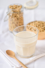 Soy milk in glass and soy bean on white background