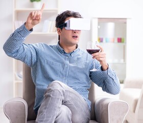 Young man drinking wine at home