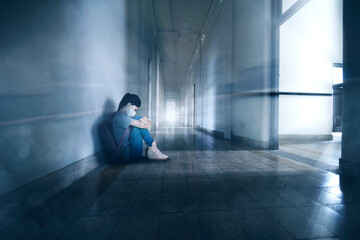 Sad female student wears mask in school corridor