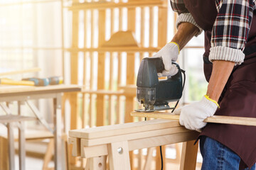Man use jigsaw for woodwork.