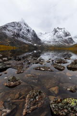 Beautiful View of Scenic Alpine Lake, Rocks and Snowy Mountain Peaks on a Cloudy Fall Day in Canadian Nature. Taken at Grizzly Lake in Tombstone Territorial Park, Yukon, Canada.
