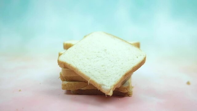 Slices of white bread falling on stock sliced bread. Shot of slow motion