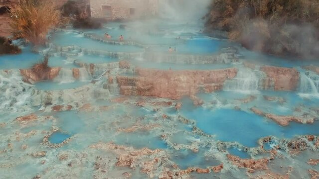 Tourists At The Cascate del Mulino (Terme di Saturnia) In Saturnia, Manciano In Italy - Steam Rising Up From The Thermal Baths.  - aerial drone shot
