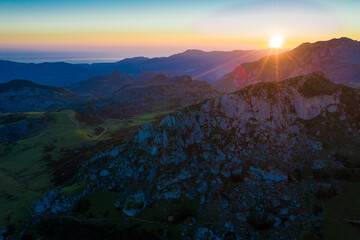 Scenic mountain landscape of Peaks of Europe with green hillsides, valleys and highland pastures during sundown, Spain..