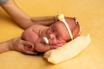 Newborn baby concept photography preparation, cute new born baby back with a bandage on the head, with photographer hands