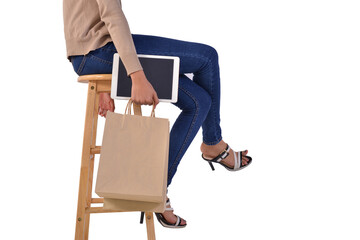 Close up woman hand holding tablet and shopping bags sitting on chair. Mock up screen for display or Advertise promotion. Isolated