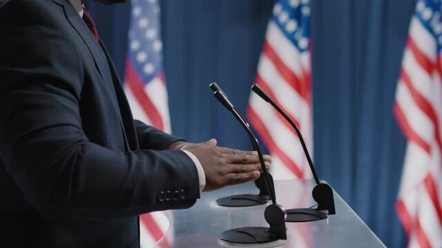 Side view shot footage of unrecognizable African American man taking part in election debates using hand gestures when speaking