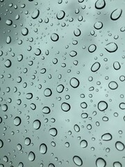 Image of water droplets on a clear glass surface during heavy rain.