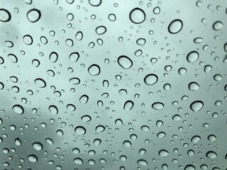 Image of water droplets on a clear glass surface during heavy rain.