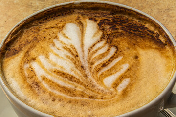 Cup of coffee cappuccino with a picture on the table