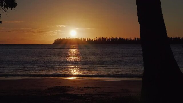 Slow tracking shot of beautiful golden sunset on Kuto Beach, Isle of Pines. 48 fps.