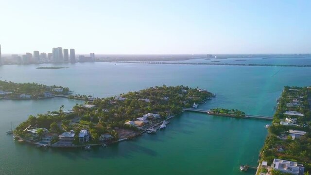 Aerial view towards Rivo Alto isle of the Venetian islands, during sunrise, in Miami, Florida - dolly, tilt down, drone shot