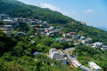 landscape view of JiuFen Village with mountain residental buildings and blue sky.