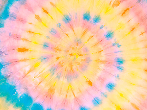Rainbow golden spiral tie dye background pattern. Swirl hippie tiedye wallpaper. Boho festive tie-dye backdrop.