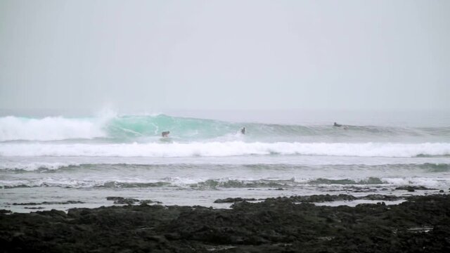 Surfer riding and turning with spray on powerful ocean wave.Surfing ocean lifestyle.