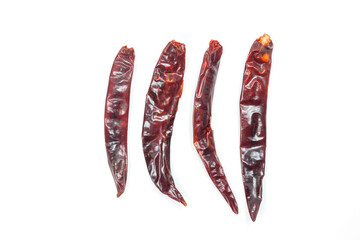 Dried red chili of various sizes placed in a row isolated on white background.