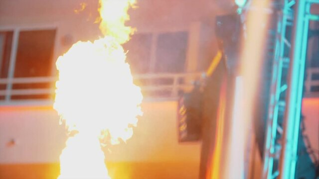 Flames shooting up at a festival by a stage at night - Slow-motion party footage - Pyrotechnics