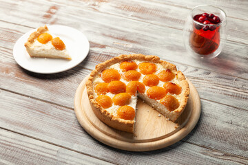 Homemade peach cheesecake, berry tea cup, piece of pie near on plate