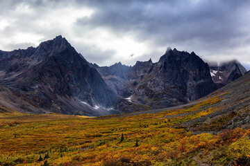 Beautiful View of Dramatic Mountains and Valley during Fall in Canadian Nature. Aerial Shot. Taken in Tombstone Territorial Park, Yukon, Canada.
