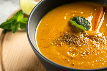 Curried carrot soup with baked peppers and cheese, lime juice and ginger, served with nuts and fresh mint, Close up