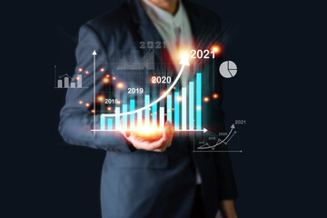 Businessman investor man hand holding trend chart growing up from 2020 to 2021, Business investment growth up concept.