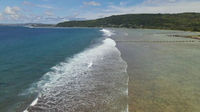 Low flying aerial shot of Waves and Asan Point Guam
