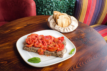 Arabic kebab spicy with tomato on top in Turkish on the wood background
