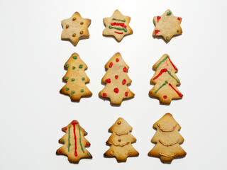 Homemade Christmas gingerbread cookies isolated on white background. Pine and star shaped cookies. Decorated Christmas cookies