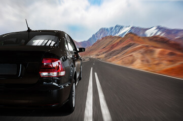 Close-up of a black car on the highway. travel by car. high-speed road along the mountains