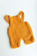 Various colors and types of cotton clothing, knitted newborn clothes and newborn hats on a white background.