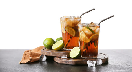 Glasses of tasty Cuba Libre cocktail on table against white background