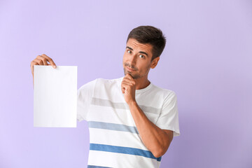 Young man with blank paper sheet on color background