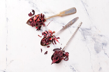 Spoons with dry hibiscus tea on table © Pixel-Shot