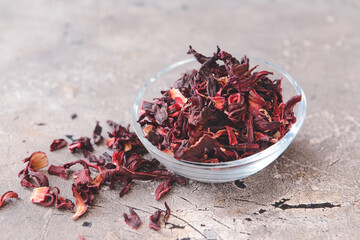 Bowl with dry hibiscus tea on table