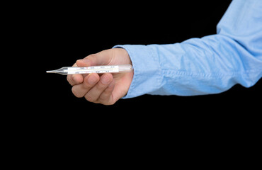 Hand holding mercury thermometer in front of black background
