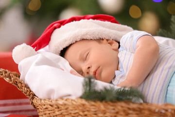 Cute little baby sleeping in basket at home on Christmas eve