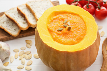 Tasty pumpkin cream soup on table