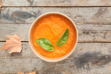 Tasty pumpkin cream soup in cup on table