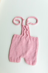 Various colors and types of cotton clothing, knitted newborn clothes and newborn hats on a white background.