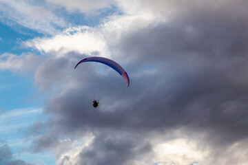 Paraglider flying Up High surrounded by Clouds in Canadian Nature. Taken in Tombstone Territorial Park, Yukon, Canada.